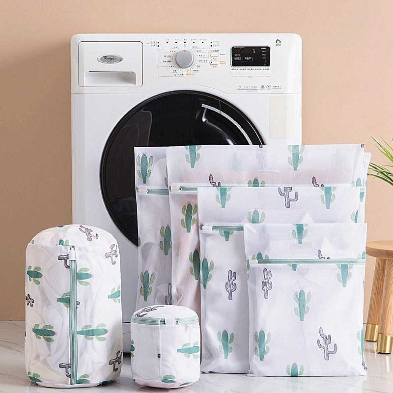 Set of clear bags with cactus pattern in front of a washing machine.