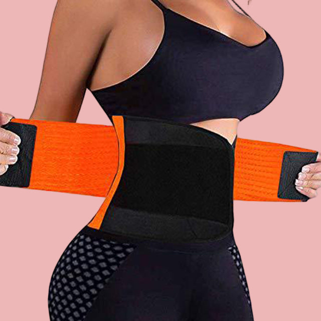 Person wearing an orange and black waist trainer on a white background
